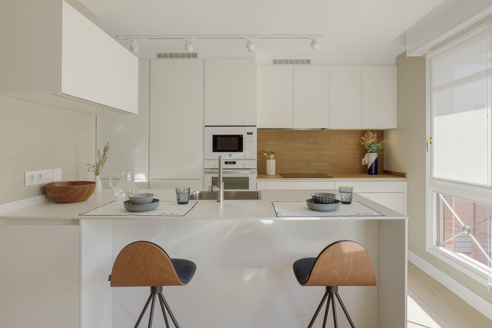 Cocina blanca con península diseñada por Cocinas Santos.