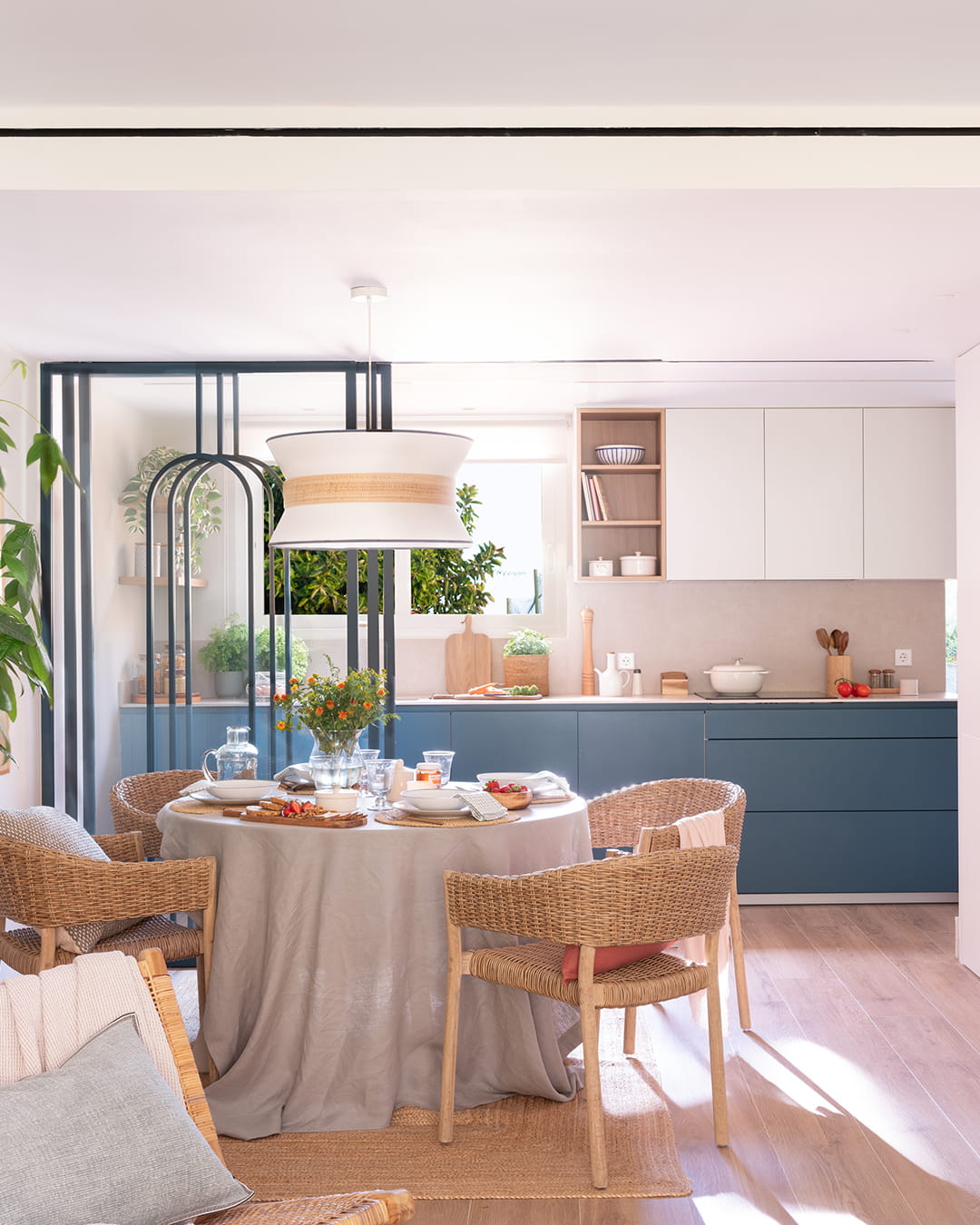 Cocina blanca y azul abierta al salón en un proyecto de Santos y Majo Flores.