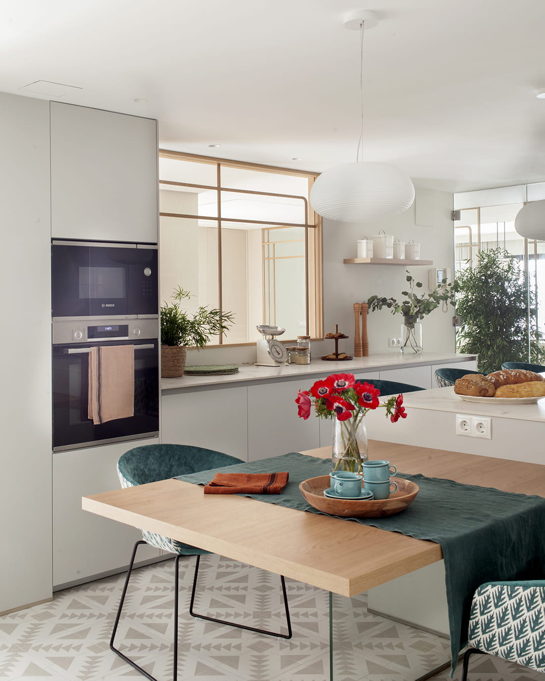 Cocina gris con isla y armarios en columna de la marca Santos.