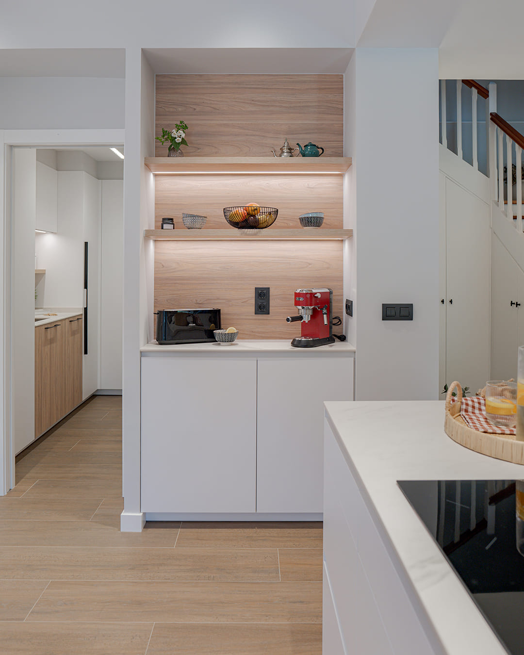 Desayunador en una cocina blanca y madera de Cocinas Santos.