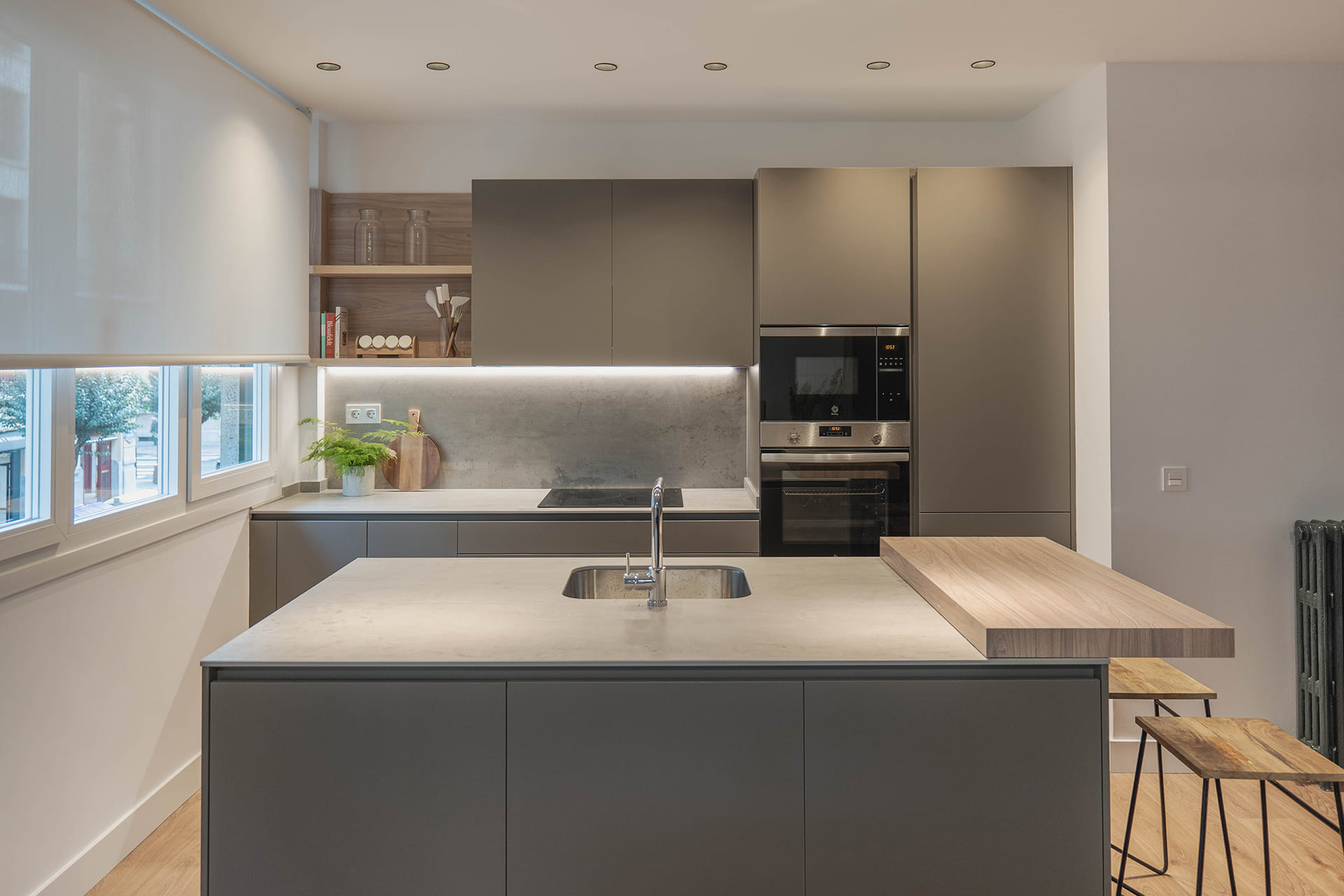 Isla de cocina con barra de madera en un diseño de Santos.