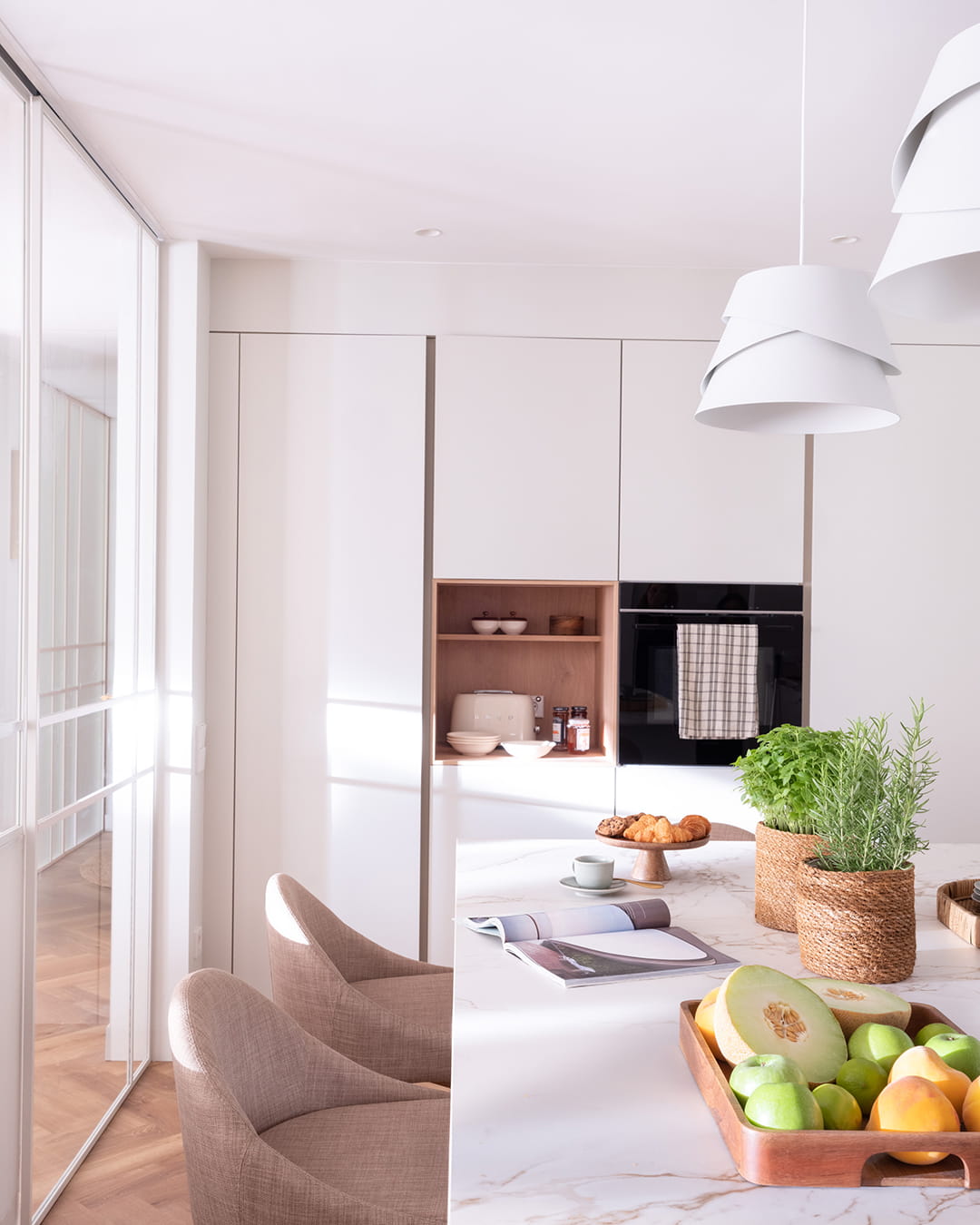Isla de cocina y armarios en columna en una cocina Santos abierta al salón.