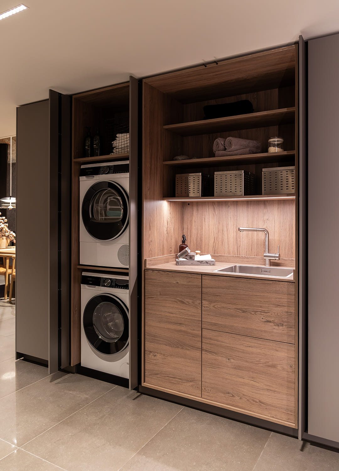 Armarios en columna con zona de lavandería en el showroom de cocinas Santos en Girona.