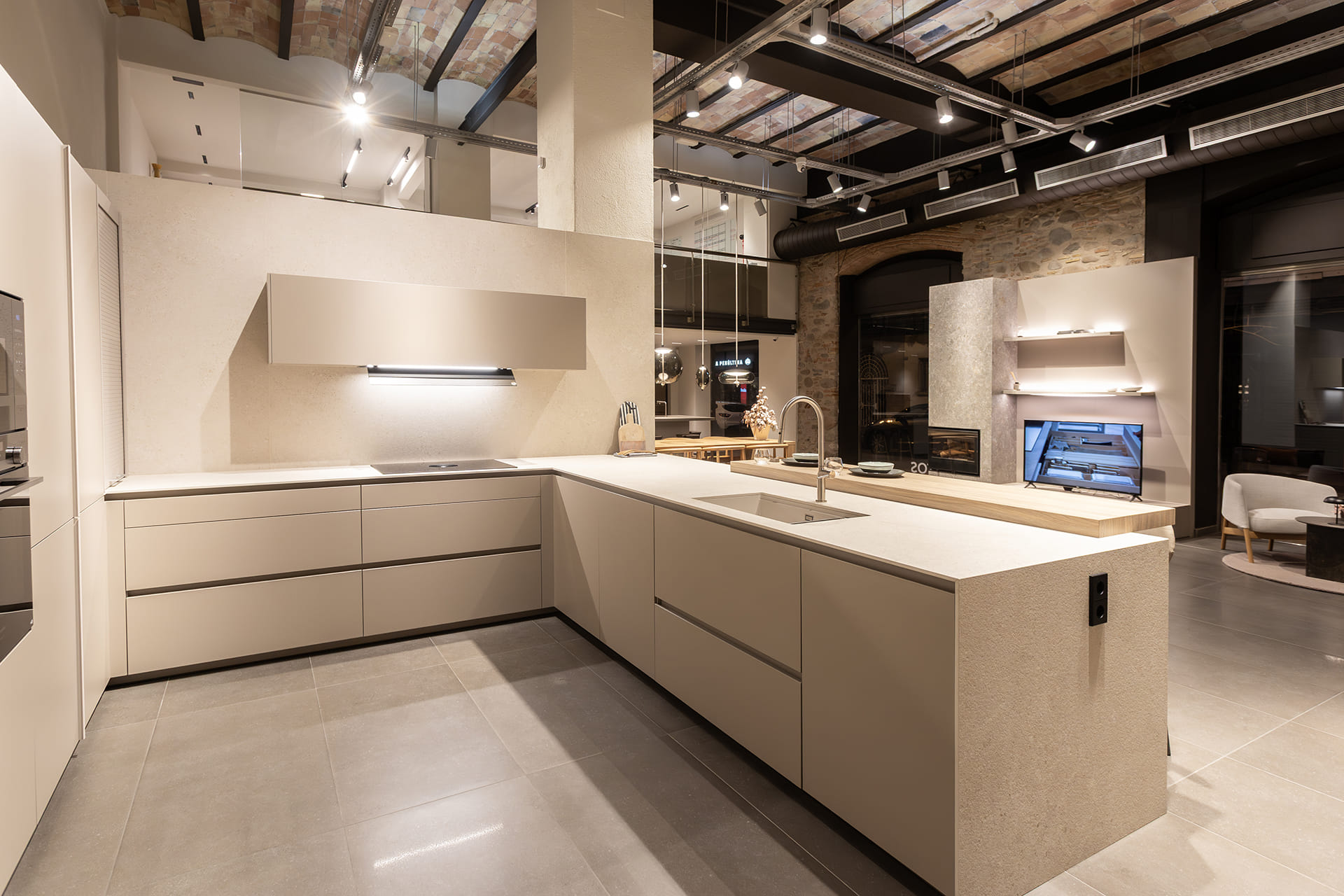 Cocina gris Arena con península en el showroom de cocinas Santos en Girona.