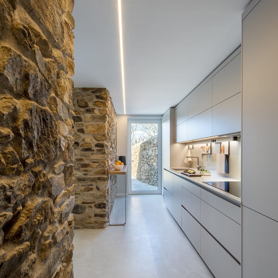 Cocina Santos color Cashmere abierta al exterior con una barra de madera.