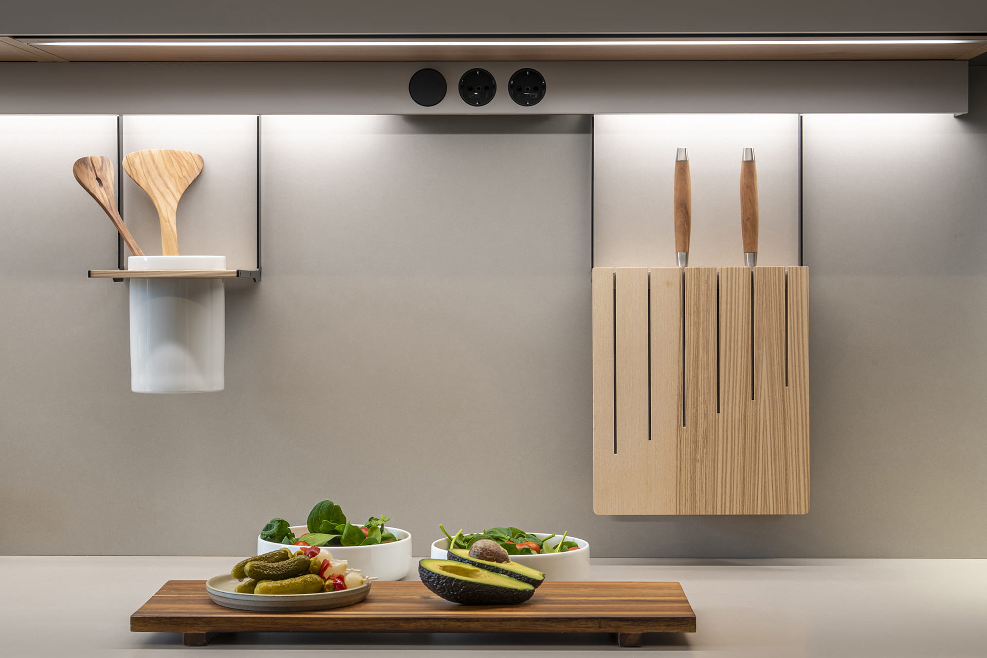 Detalle de la encimera con portaútiles y enchufes en una cocina Santos Cashmere.