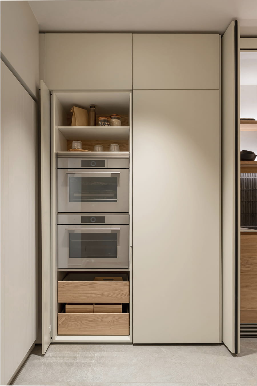 Armarios escamoteables con electrodomésticos integrados en el showroom de Cocinas Santos en Suiza.
