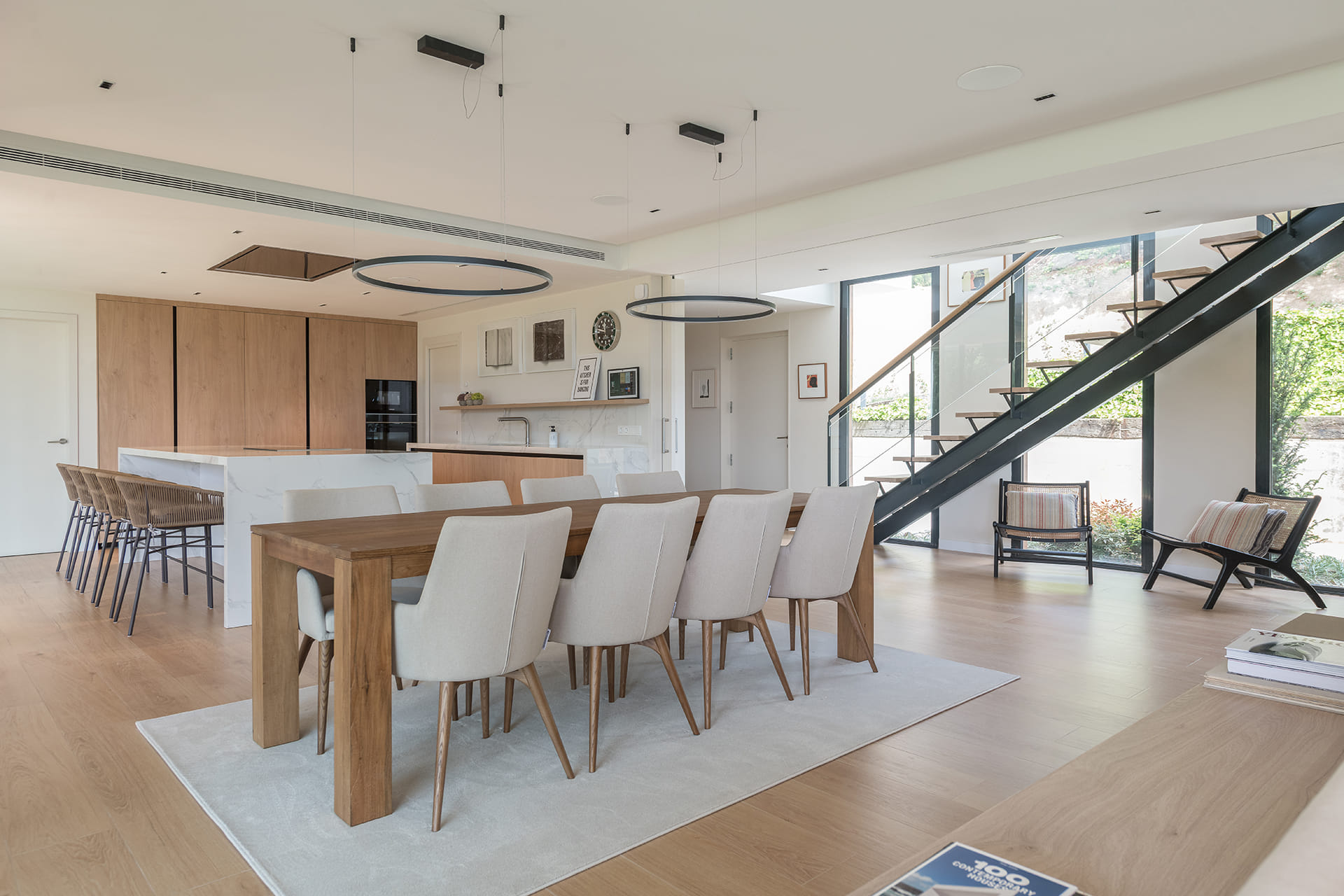 Cocina blanca y madera abierta a la zona de comedor diseñada por Santos.