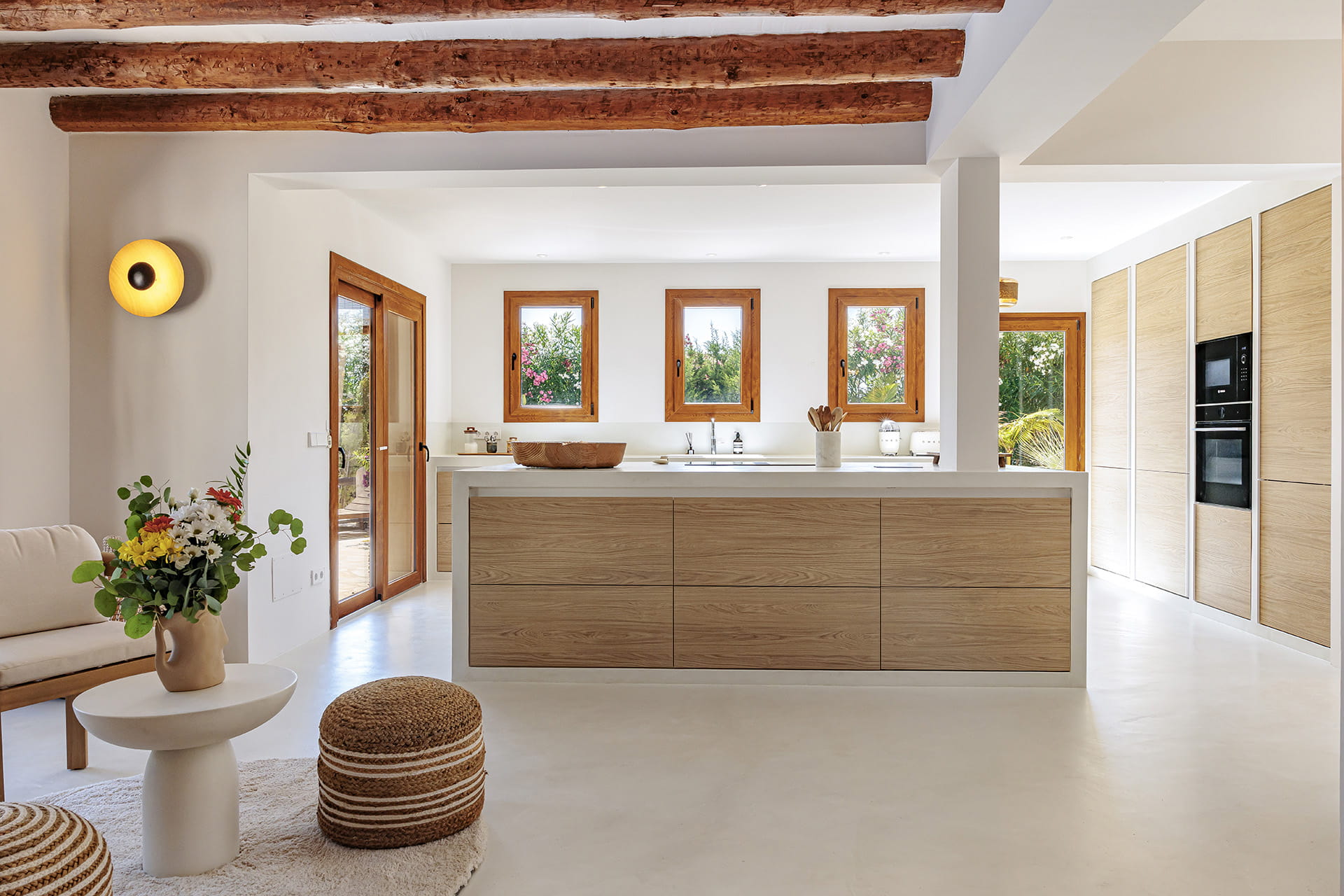 Cocina blanca y madera abierta a la zona exterior diseñada por Cocinas Santos.