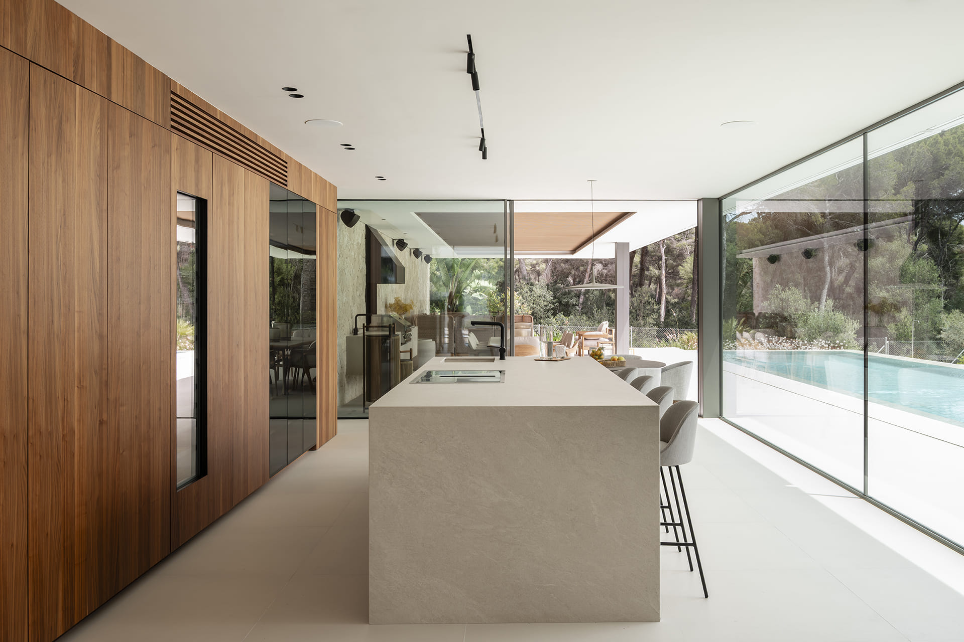 Cocina blanca y madera abierta a zona exterior diseñada por Cocinas Santos.