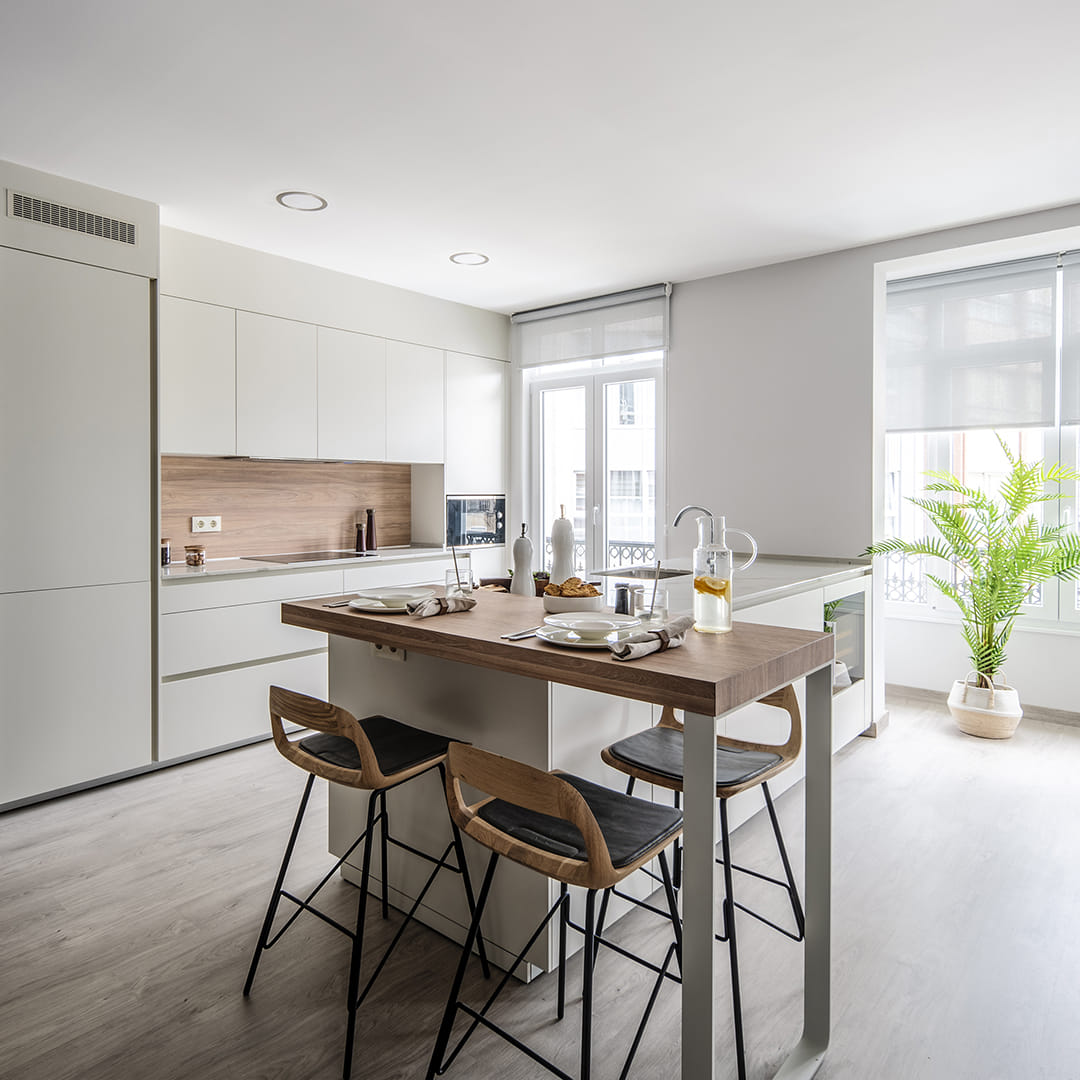 Cocina Blanco Perla con península y mesado de madera de Santos.