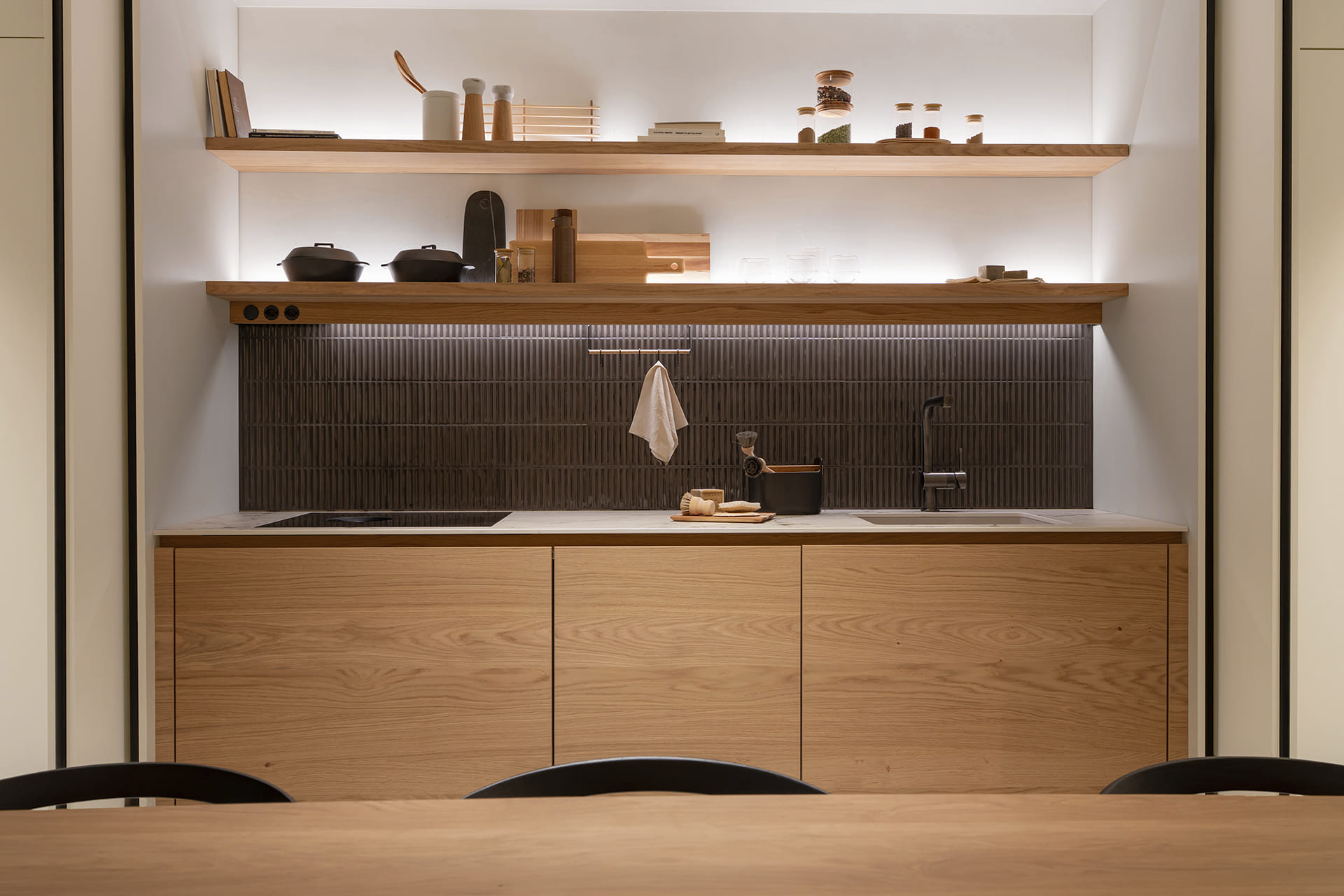 Cocina lineal con sistema de puertas escamoteables dobles en la nueva tienda eba Genève.