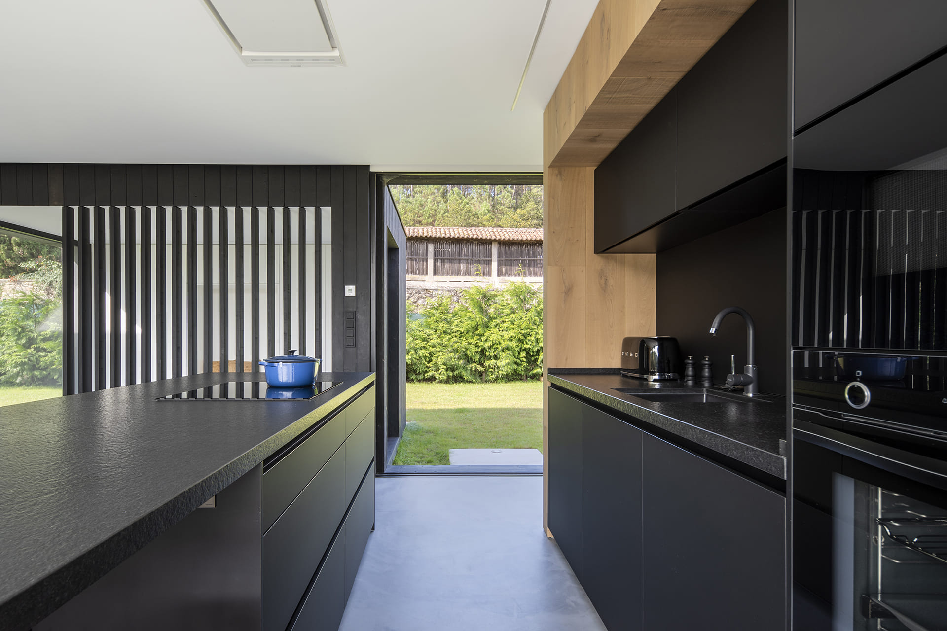 Cocina en color negro y madera abierta al exterior de Cocinas Santos.