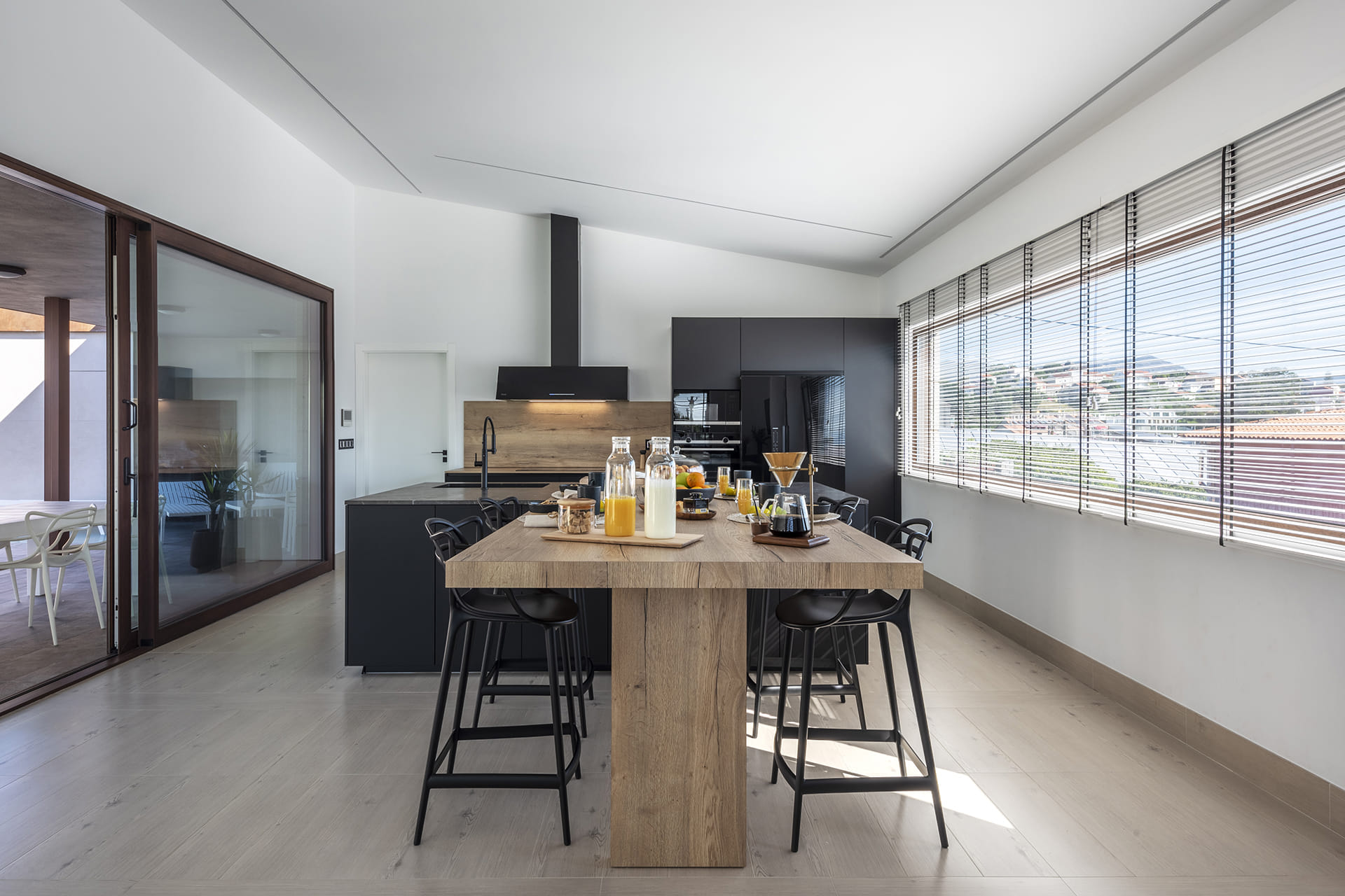 Cocina negra y madera con mesado de madera en un proyecto de Cocinas Santos.
