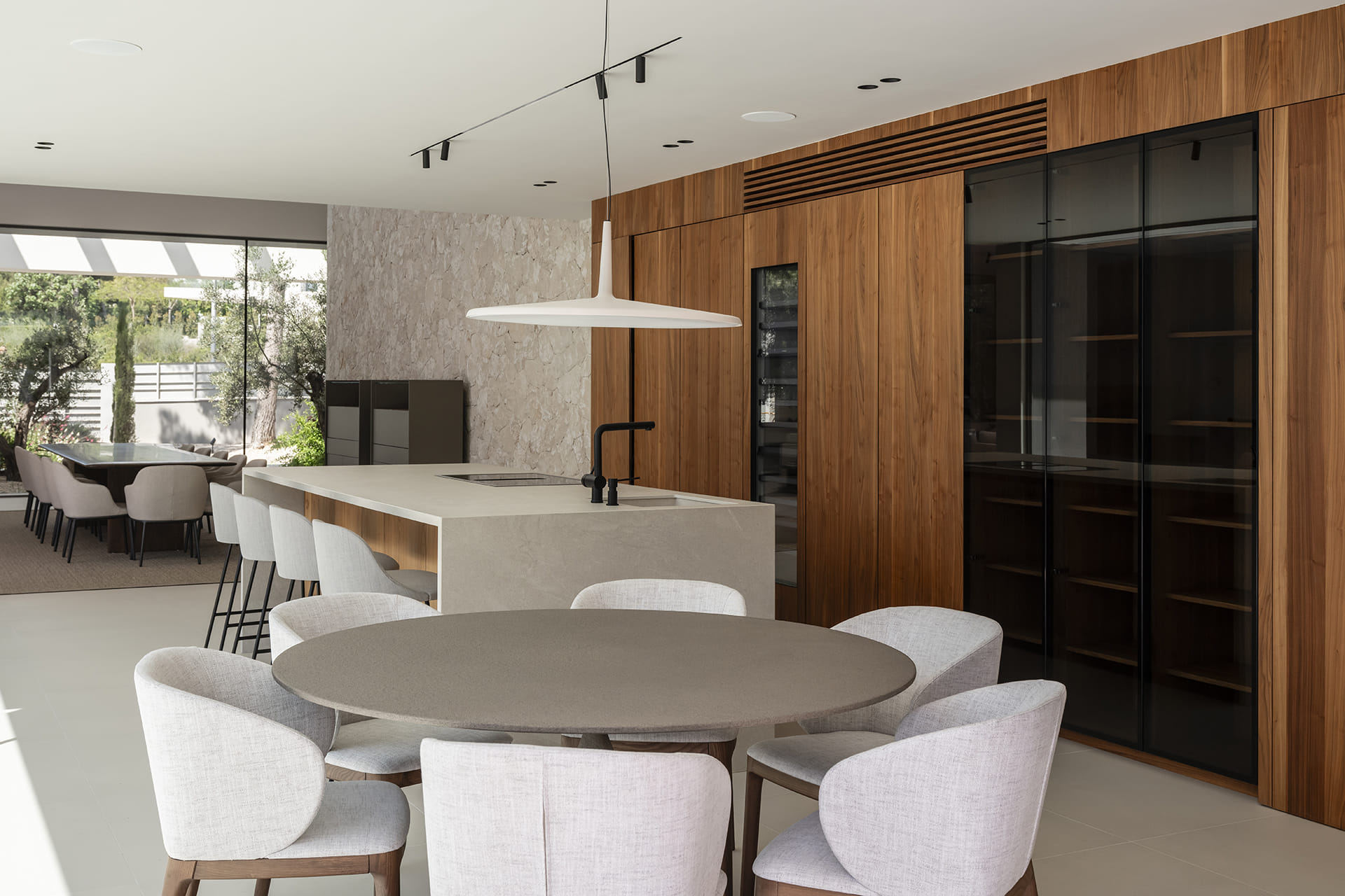 Zona de comedor con una cocina Santos con isla central al fondo.