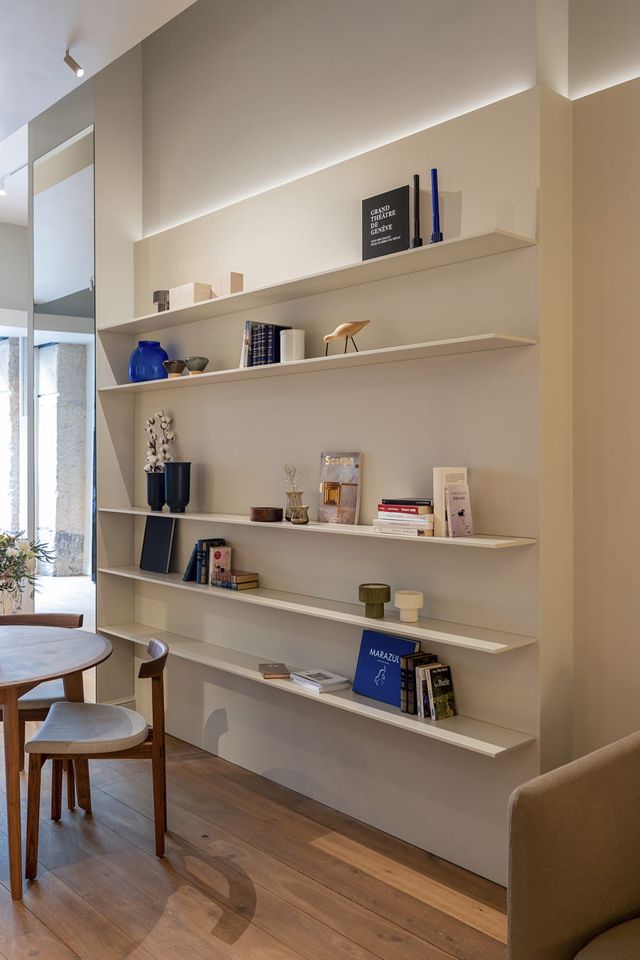 Estanterías blancas en la zona de living del showroom de Cocinas Santos en Suiza.
