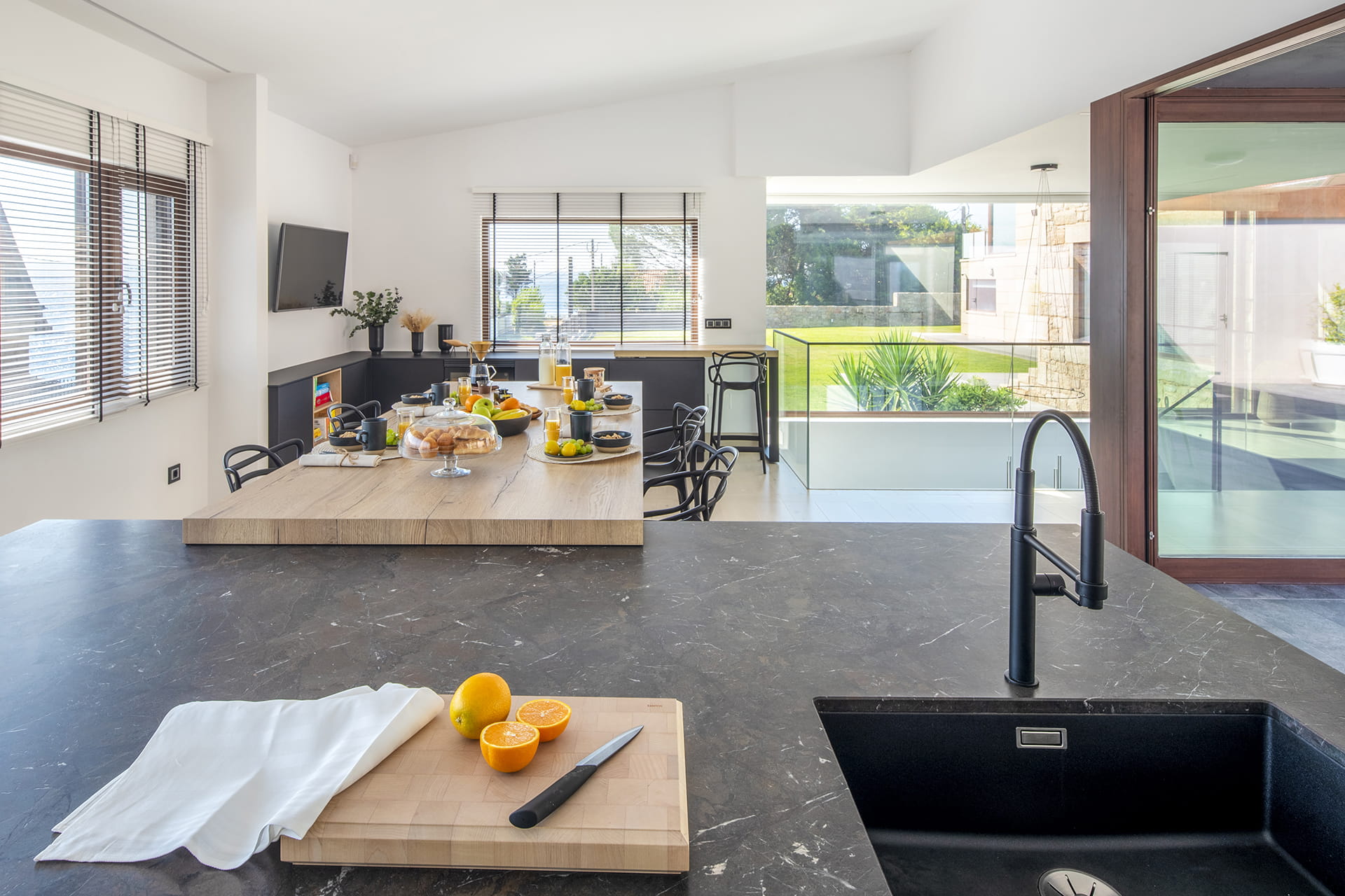 Isla de cocina con fregadero integrado y mesado de madera en un proyecto de Cocinas Santos.