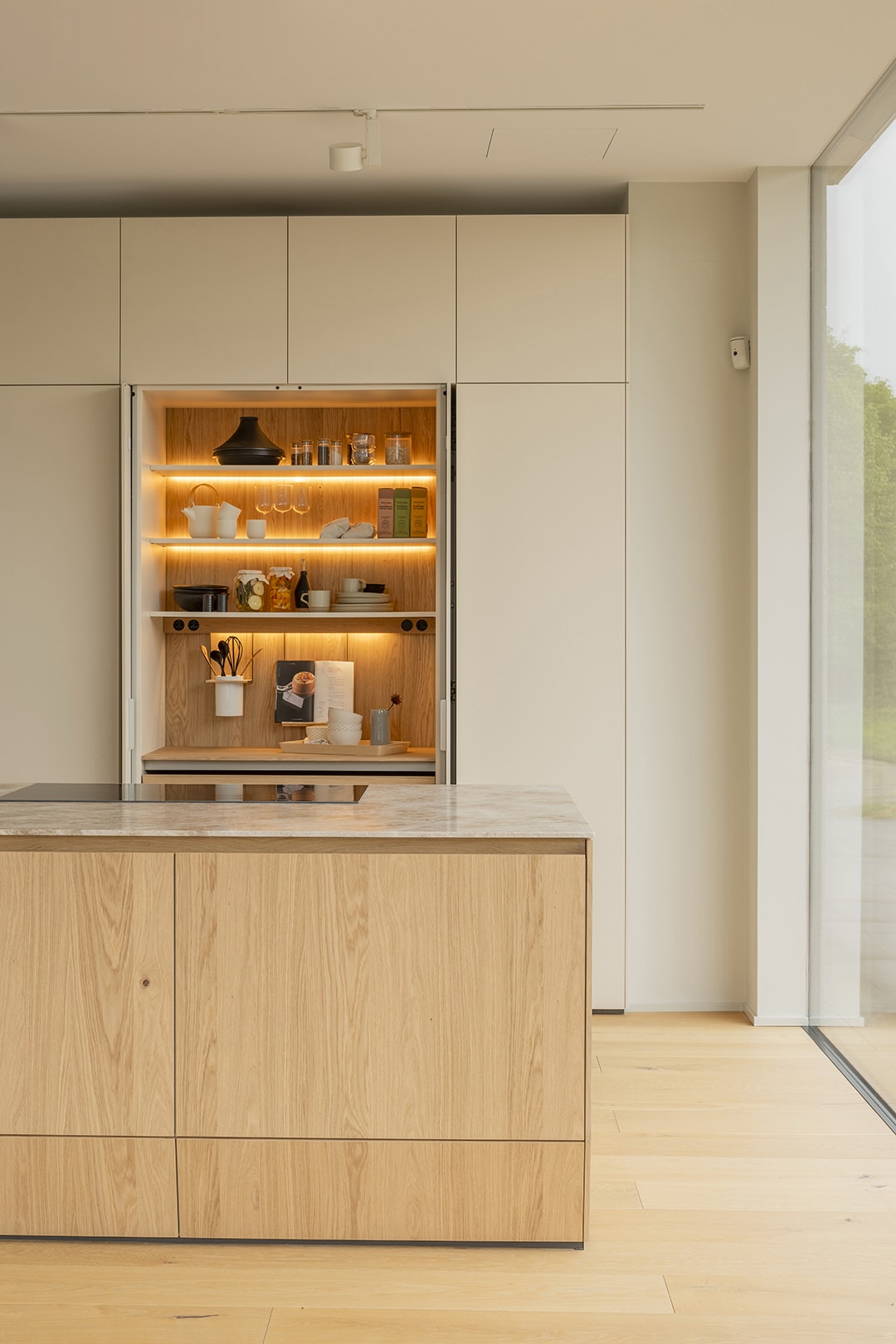 Armario de cocina con puertas escamoteables e iluminación interior en la nueva exposición de Santiago Interiores.