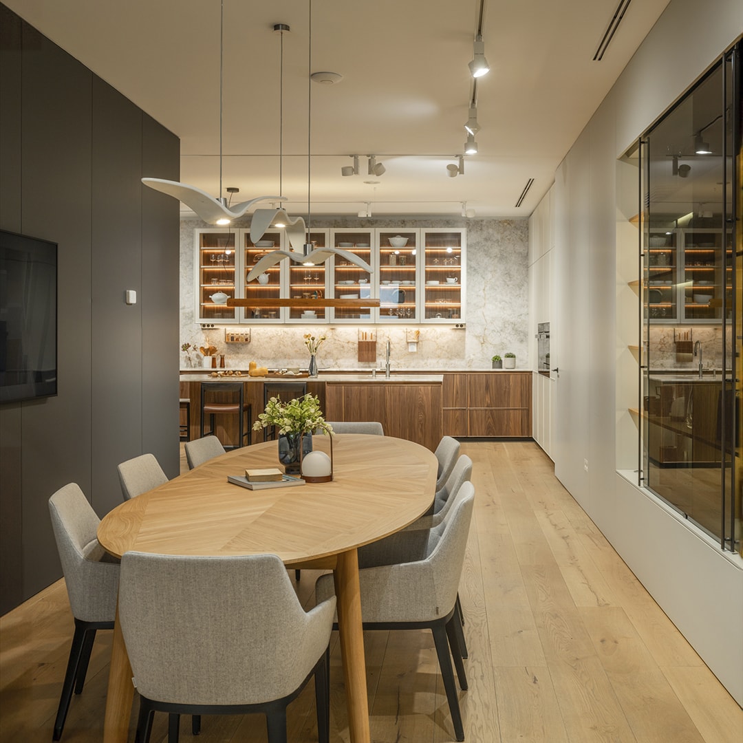 Cocina abierta al salón con acabados en madera en la nueva exposición de Cocinas Santos en Santiago.