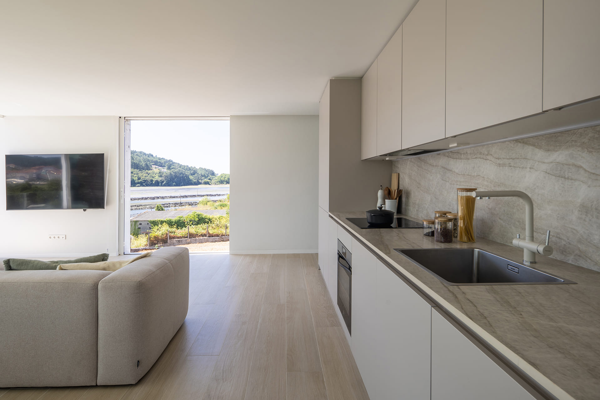 Cocina con distribución lineal abierta al salón diseñada por Santos.