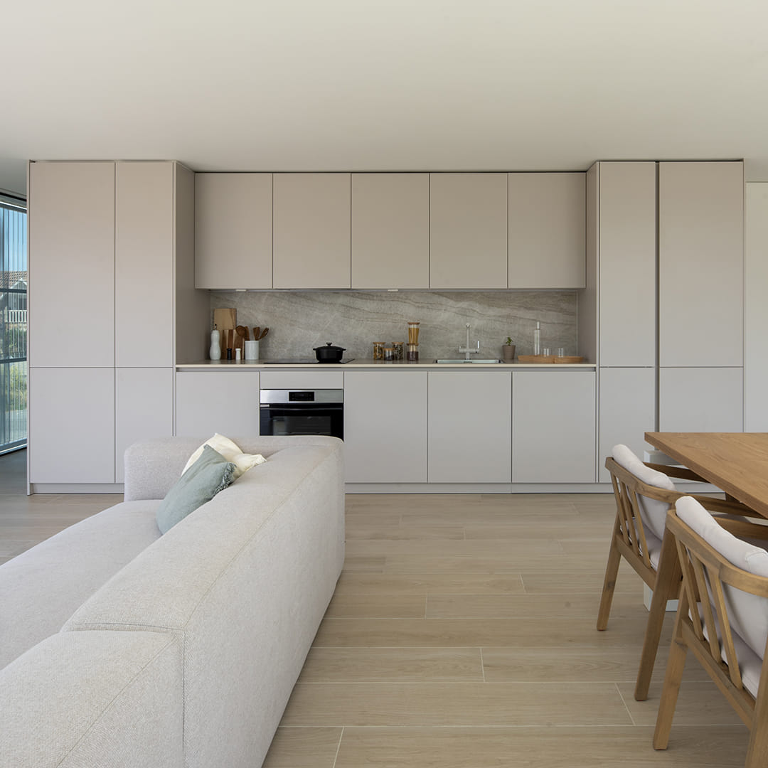 Cocina lineal abierta al salón con muebles Cashmere de Santos.