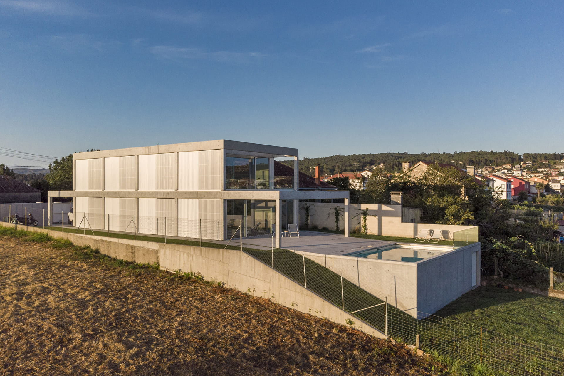 Vista exterior trasera de una vivienda con piscina y una cocina Santos.