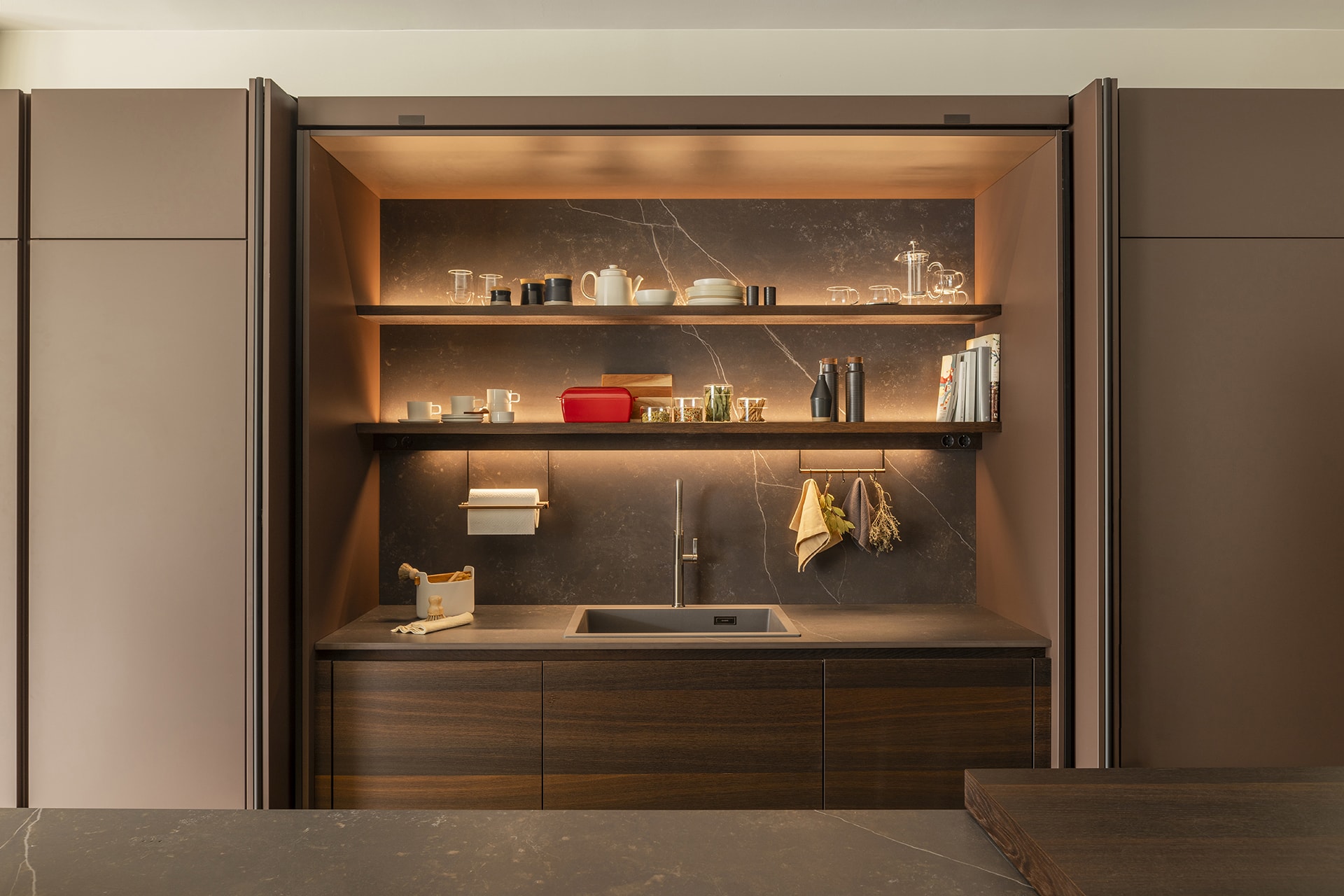 Zona de fregadero integrada en mueble con puertas escamoteables en la exposición de Cocinas Santos en Santiago.