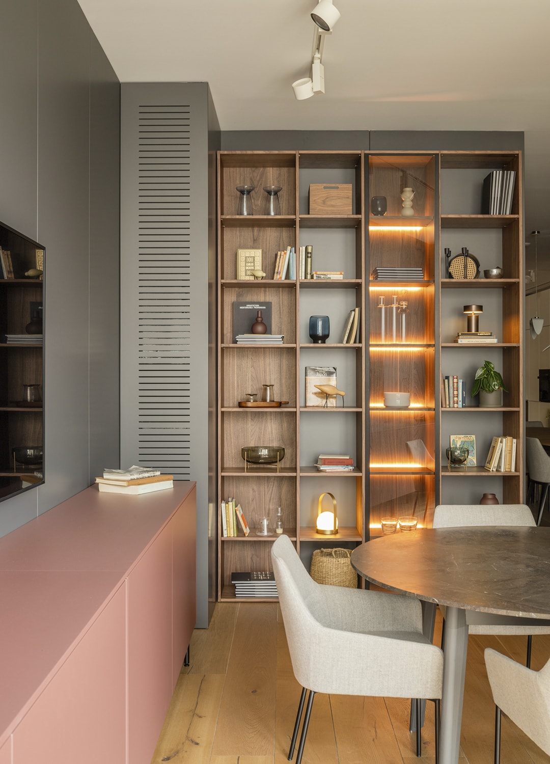 Librería modular de madera y vitrinas en la zona de estar del showroom de Santos en Santiago.