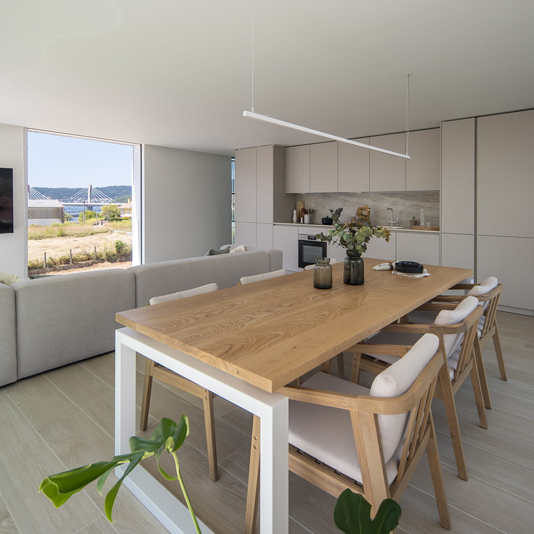 Mesa de comedor frente a una cocina Santos con distribución lineal.