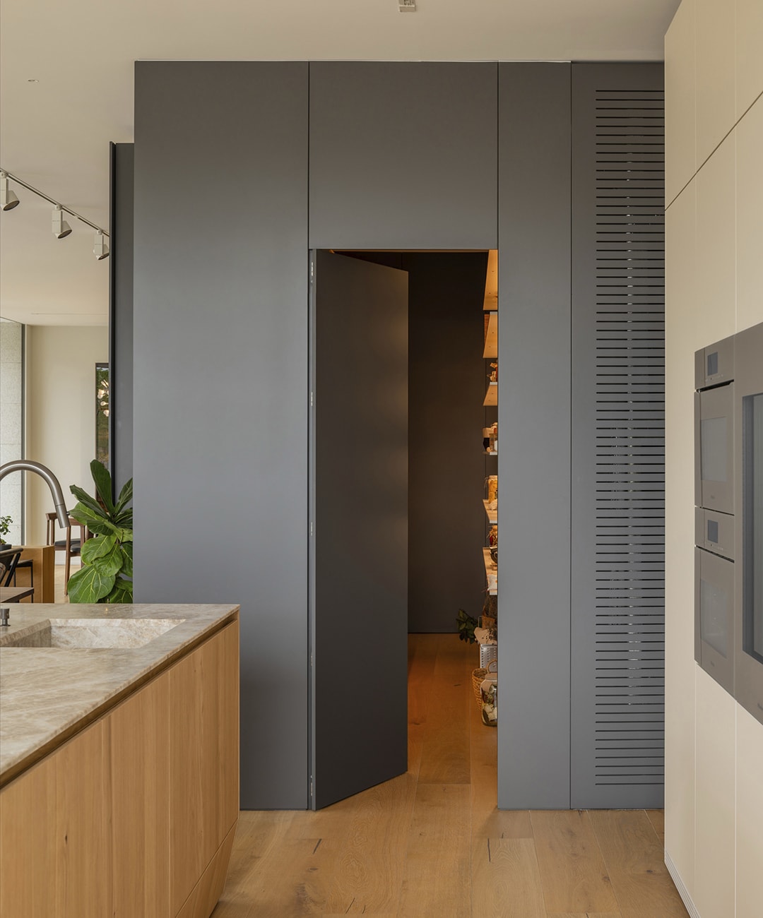 Detalle de una puerta en madera de color gris en la exposición de cocinas de Santiago Interiores.