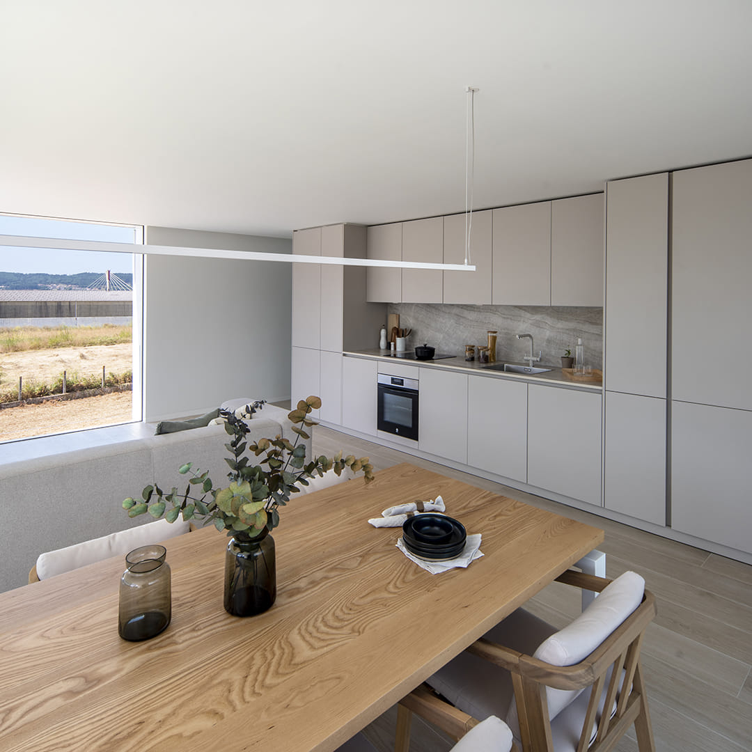 Zona de comedor con una cocina lineal de Santos al fondo.