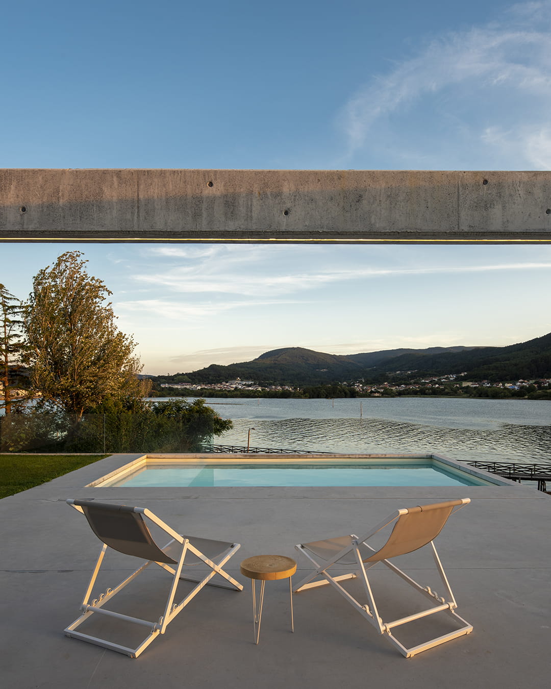 Zona de jardín y piscina en una vivienda con cocina Santos abierta al salón.