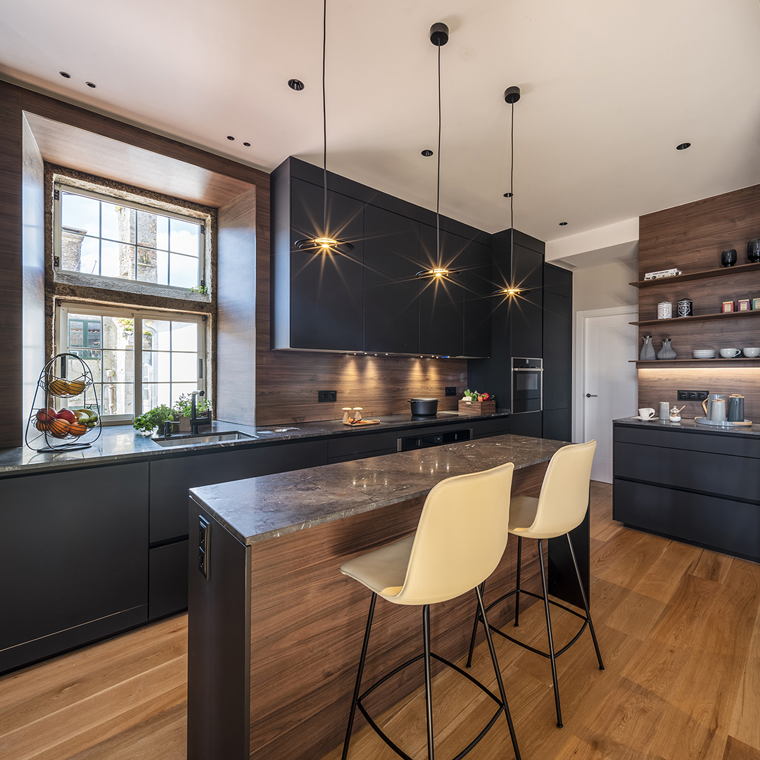 Cocina negra y de madera con isla y cerramiento de cristal Santos.