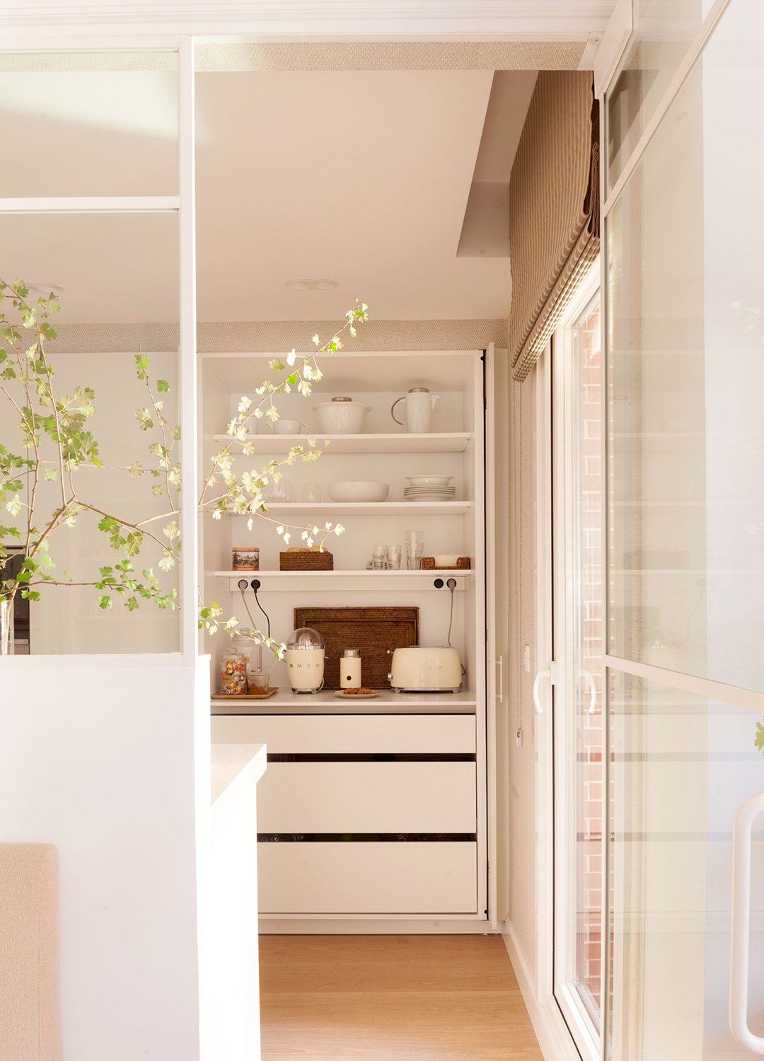 Entrada a una cocina blanca con cerramiento de cristal de Santos.
